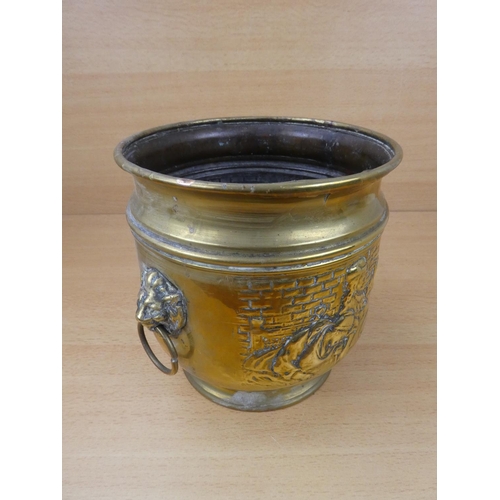 513 - A vintage brass plant pot with lion mask handles.