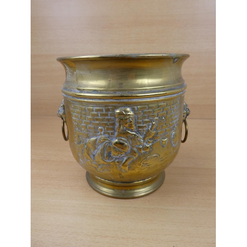 513 - A vintage brass plant pot with lion mask handles.