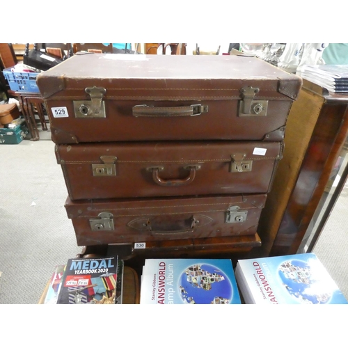 529 - Three vintage leather suitcases.