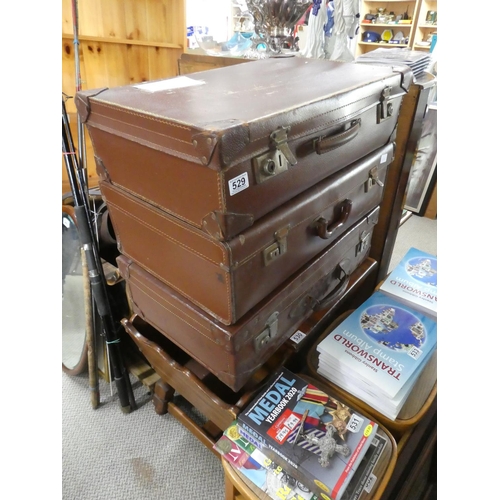 529 - Three vintage leather suitcases.