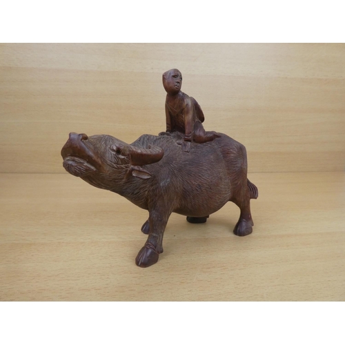 46 - An oriental wooden cow and figure.