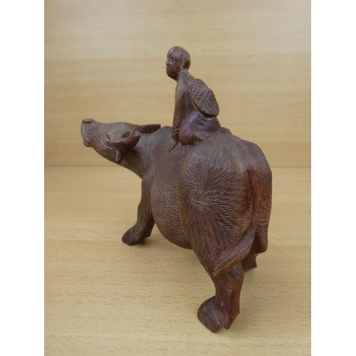 46 - An oriental wooden cow and figure.