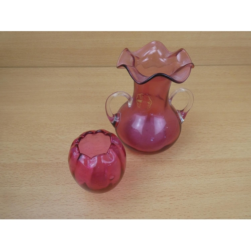 67 - A small antique ruby glass pot and a Royal Scott cranberry glass two handled vase.