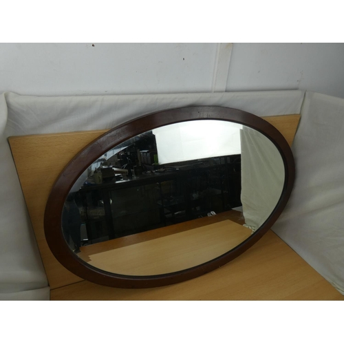 348 - A mahogany framed oval mirror, measuring 83x58cm.