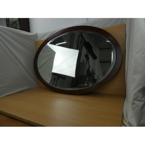 348 - A mahogany framed oval mirror, measuring 83x58cm.