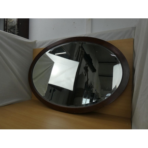 348 - A mahogany framed oval mirror, measuring 83x58cm.