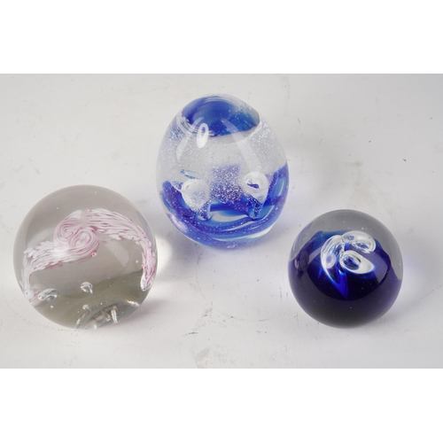 672 - Three colourful glass paperweights.