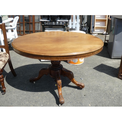 687 - A stunning antique mahogany breakfast table on a highly carved base, measuring 84x110x70cm.