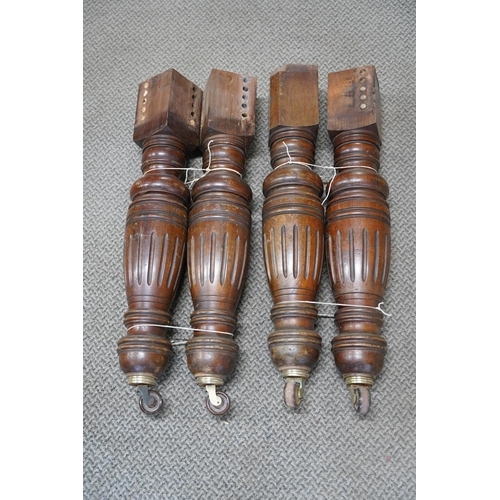 811 - A set of four antique mahogany table legs on casters.