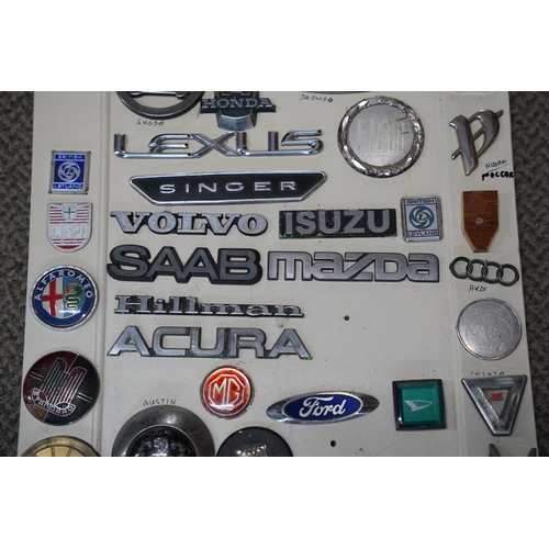 819 - A large collection of vintage car mascots and badges, mounted on board.