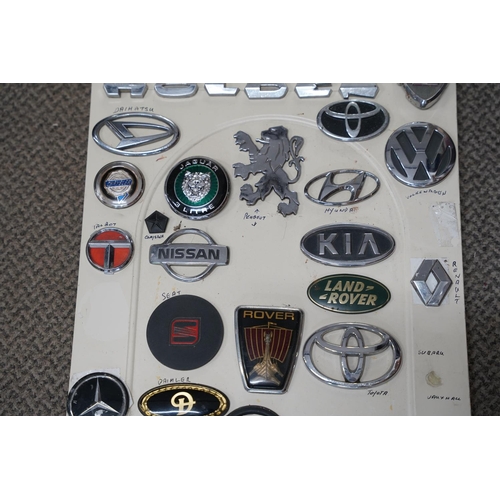 819 - A large collection of vintage car mascots and badges, mounted on board.