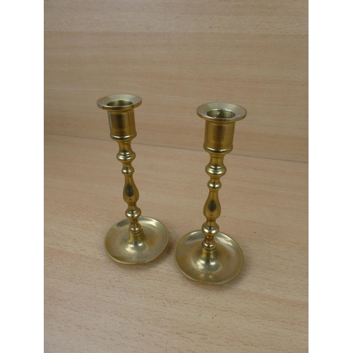 61 - A small pair of brass candlesticks.