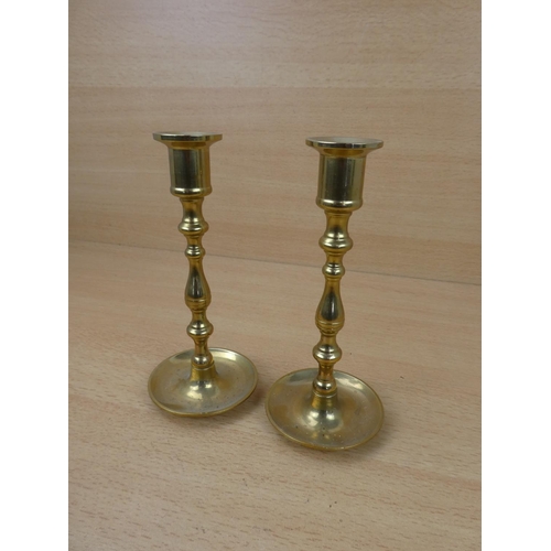 61 - A small pair of brass candlesticks.