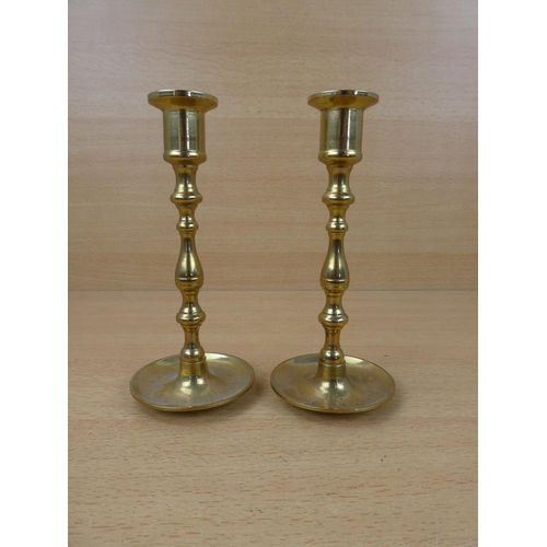 61 - A small pair of brass candlesticks.