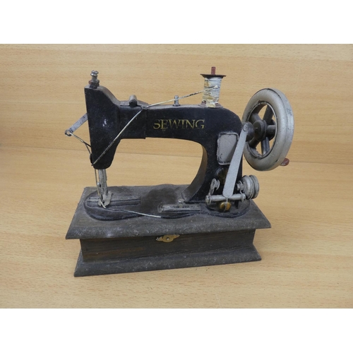 69 - A miniature sewing machine.