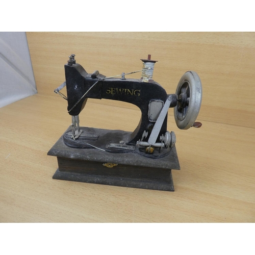 69 - A miniature sewing machine.