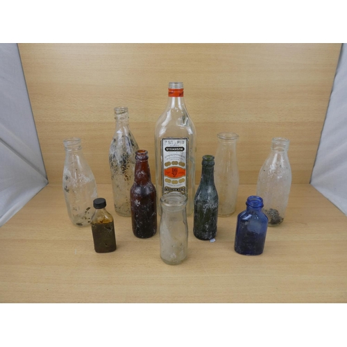 72 - A collection of vintage glass bottles to include a Bushmill's Whiskey 1.75L bottle, a Tyrone Mineral... 