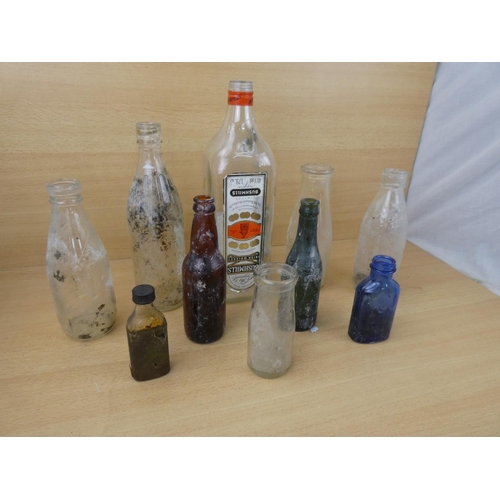 72 - A collection of vintage glass bottles to include a Bushmill's Whiskey 1.75L bottle, a Tyrone Mineral... 