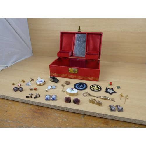 553 - A vintage jewellery box containing assorted jewellery, cufflinks, badges and more.