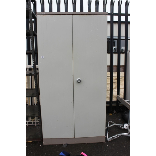 574 - A large two door metal cabinet with shelves.