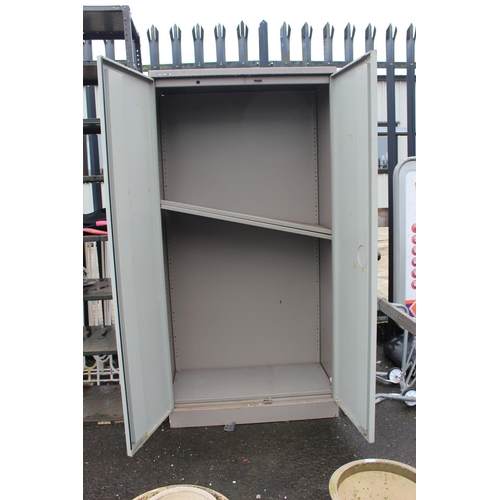 574 - A large two door metal cabinet with shelves.