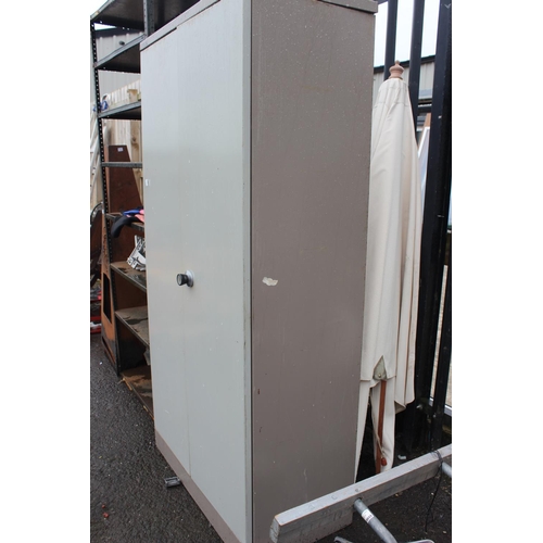 574 - A large two door metal cabinet with shelves.