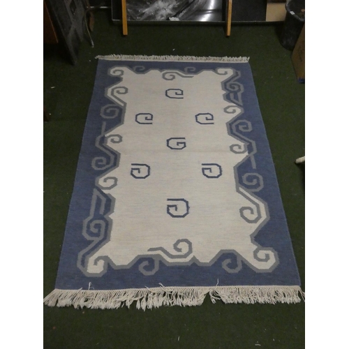 422 - A blue and cream patterned floor rug.