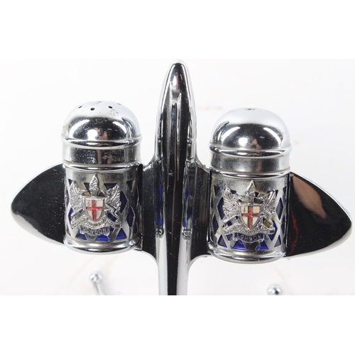 13 - A decorative salt and pepper set modelled as a plane, with cobalt blue liners and London's coat of a... 