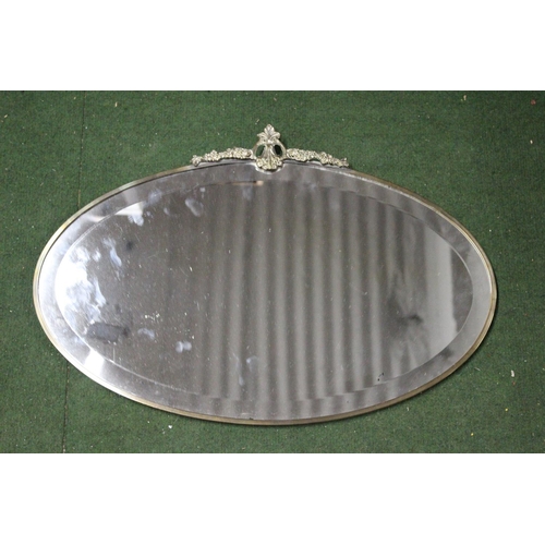 166 - A vintage bevelled glass mirror with decorative metal frame. Approx  56x38cm.