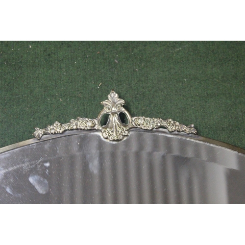 166 - A vintage bevelled glass mirror with decorative metal frame. Approx  56x38cm.