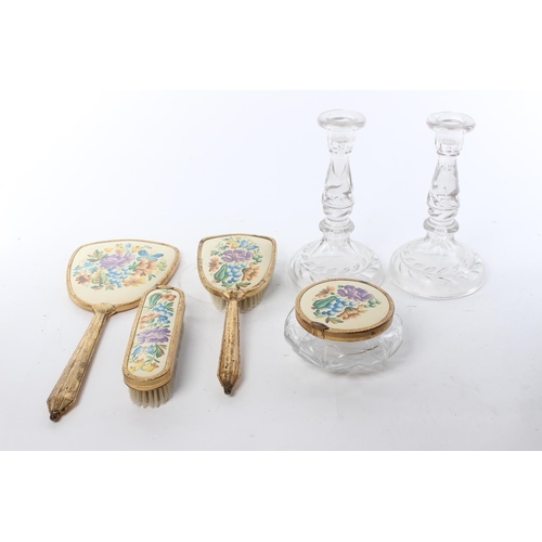 180 - A vintage dressing table set, to include a pair of glass candlesticks, a hand mirror, brush and more... 