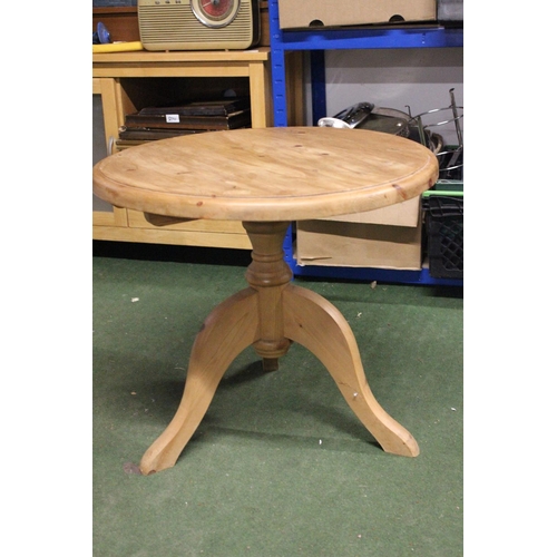 255 - A circular topped pine table on tripod base.