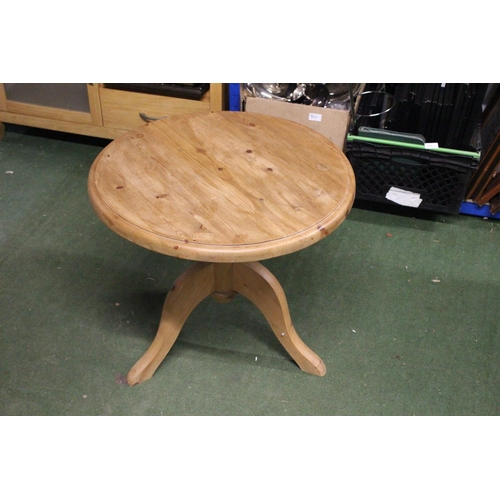 255 - A circular topped pine table on tripod base.