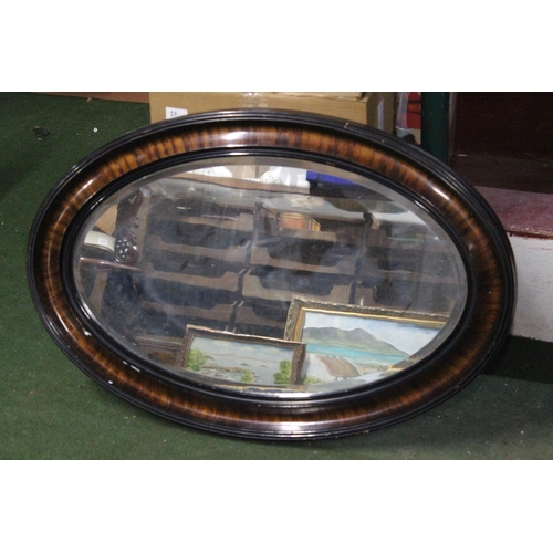 455 - An antique oval mirror with bevelled glass.