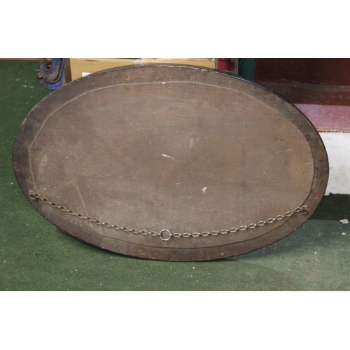 455 - An antique oval mirror with bevelled glass.