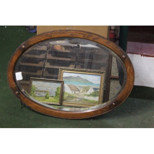 456 - An antique oval mirror with bevelled glass.