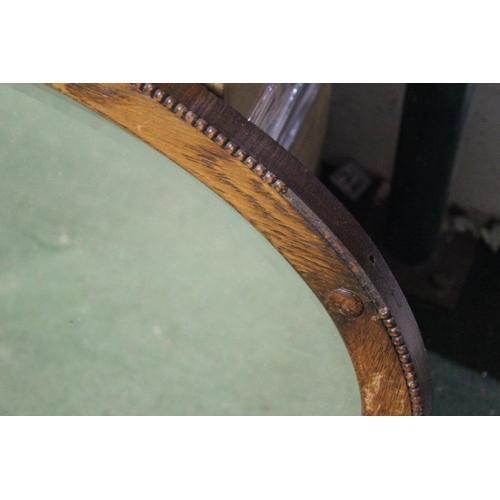 456 - An antique oval mirror with bevelled glass.