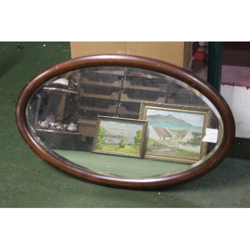 458 - An antique oval mirror with bevelled glass.