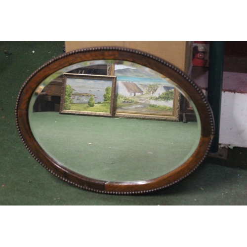 459 - An antique oval mirror with bevelled glass.