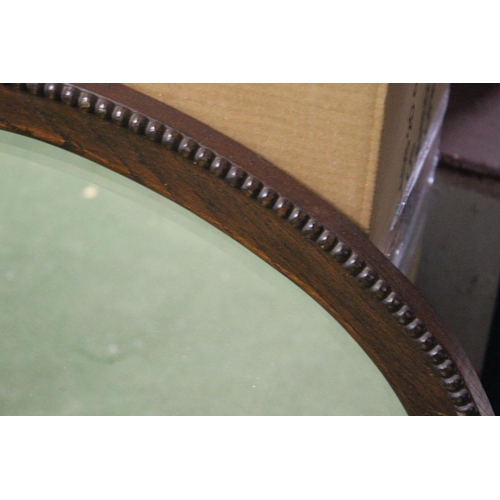 459 - An antique oval mirror with bevelled glass.