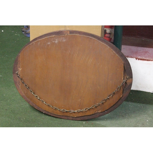 459 - An antique oval mirror with bevelled glass.