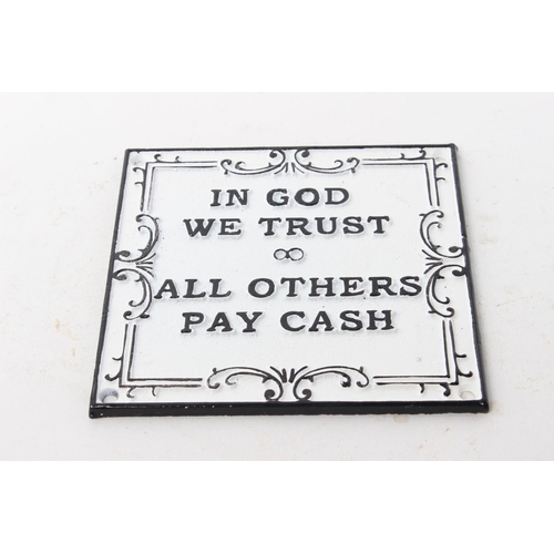 504 - A cast iron plaque, reading 'In God We Trust - All Others Pay Cash'.