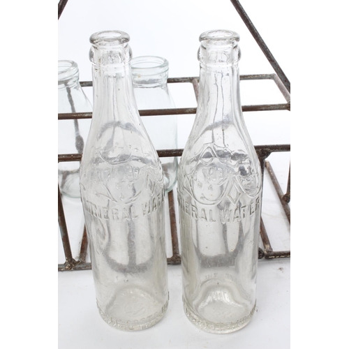 544 - A vintage metal milk bottle crate and bottles.