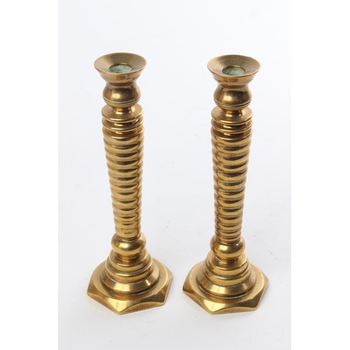 550 - An unusual pair of antique brass candlesticks. Measuring 16cm tall.