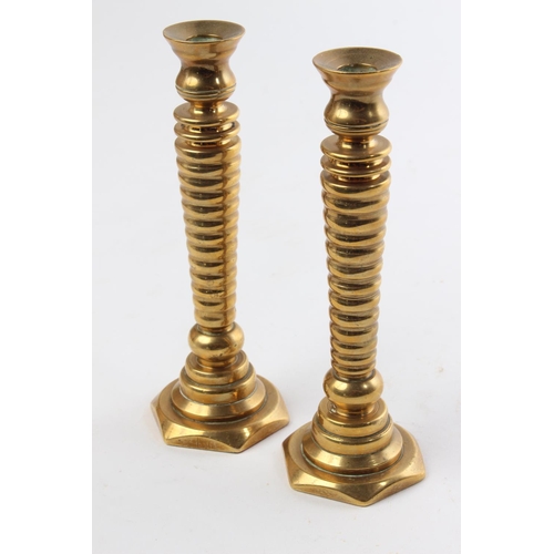 550 - An unusual pair of antique brass candlesticks. Measuring 16cm tall.