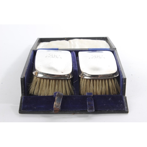 153 - A cased pair of antique silver mounted engraved dressing table brushes.