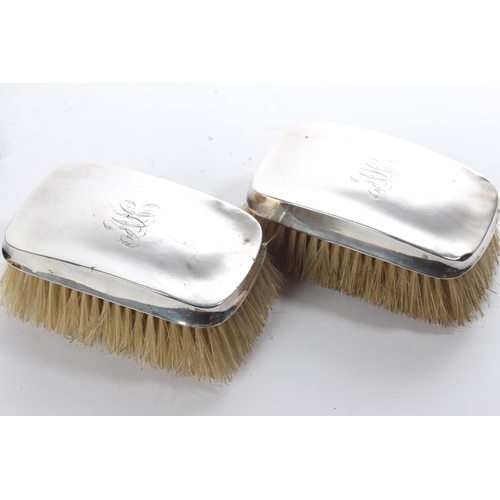 153 - A cased pair of antique silver mounted engraved dressing table brushes.