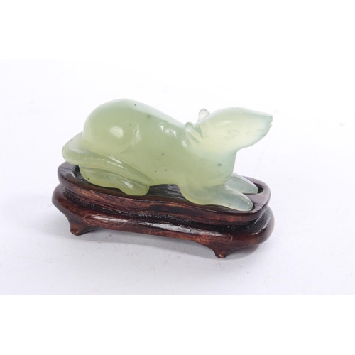 156 - A small jade figure of a rat on a hardwood stand.