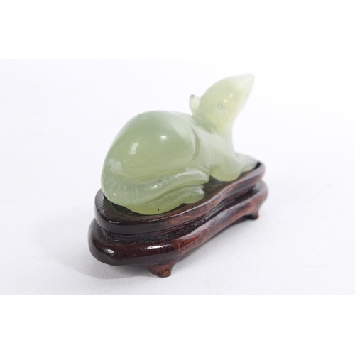 156 - A small jade figure of a rat on a hardwood stand.