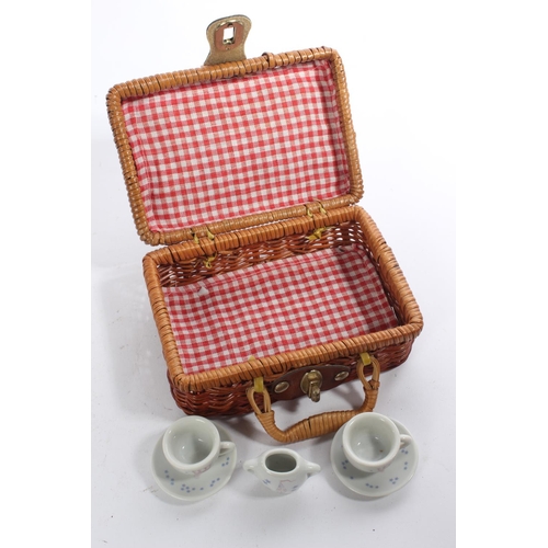 176 - A miniature wicker picnic basket and ceramic tea set.